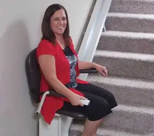 Woman riding a stair lift in her home.